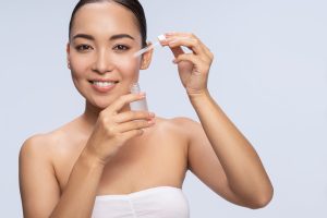Jeune femme qui applique du sérum sur ses cernes