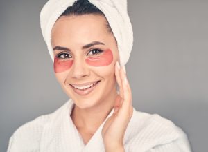 Femme avec des masques hydratants pour les yeux