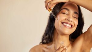 Femme qui met un sérum sur sa peau